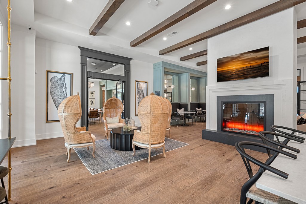 clubhouse modern living room with a fireplace and four chairs for seating.