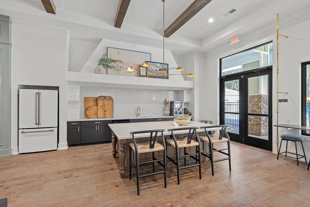 Clubhouse kitchen with a countertop table and barstool chairs.