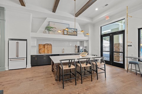 Clubhouse kitchen with a countertop table and barstool chairs.