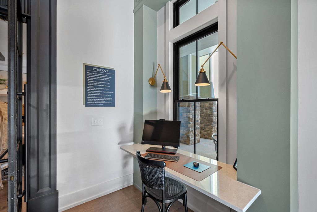 Corner area with a desk and a computer on it with lighting.