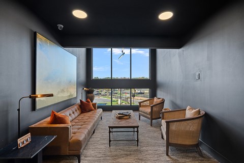 A living room with seating and a large window.