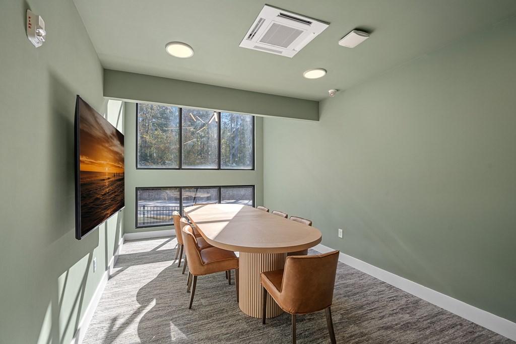 A conference room with a large table and chairs.