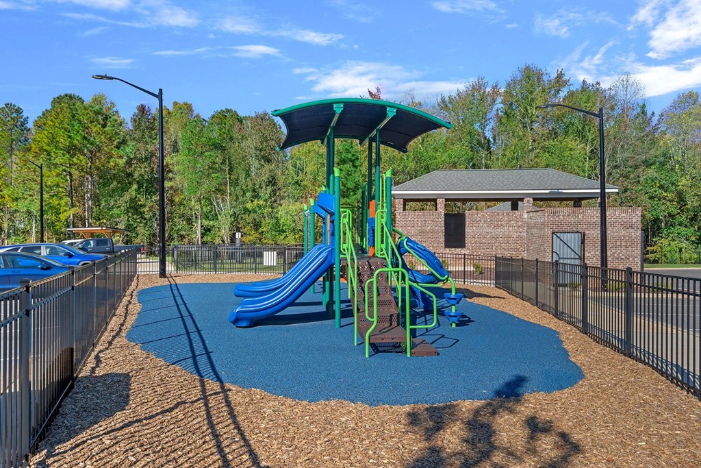 A playground with a blue slide and a green canopy.