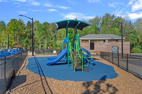 A playground with a blue slide and a green canopy.