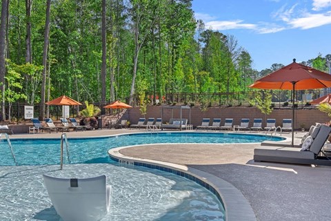 A large swimming pool with a white lounger in the pool and other loungers outside the pool.