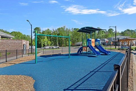 A playground with a blue slide and a green swing set.