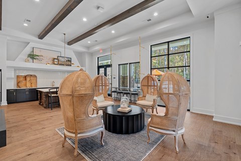 A living room with a round coffee table and four chairs.