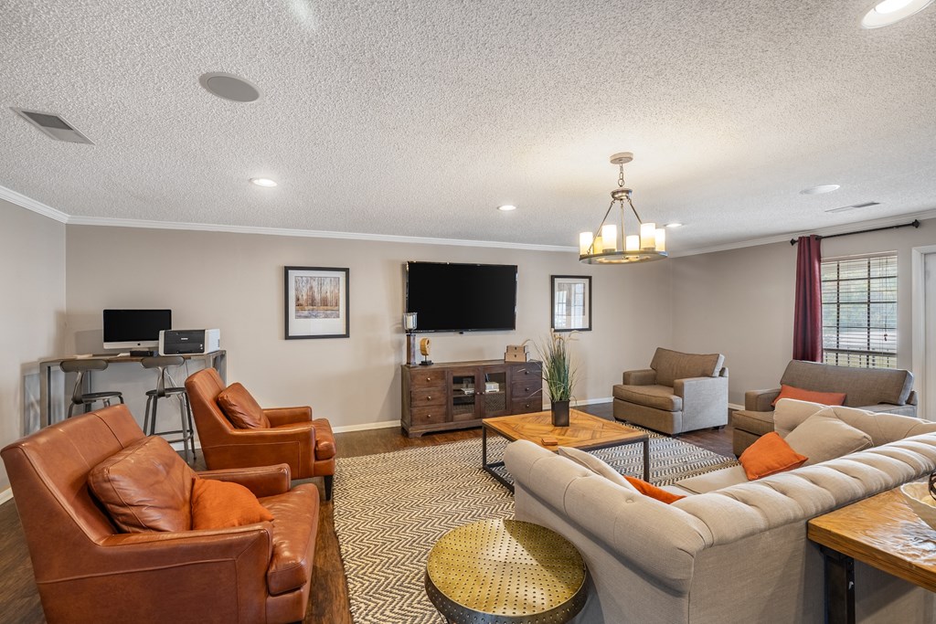 A living room with a brown leather chair and a grey sofa.