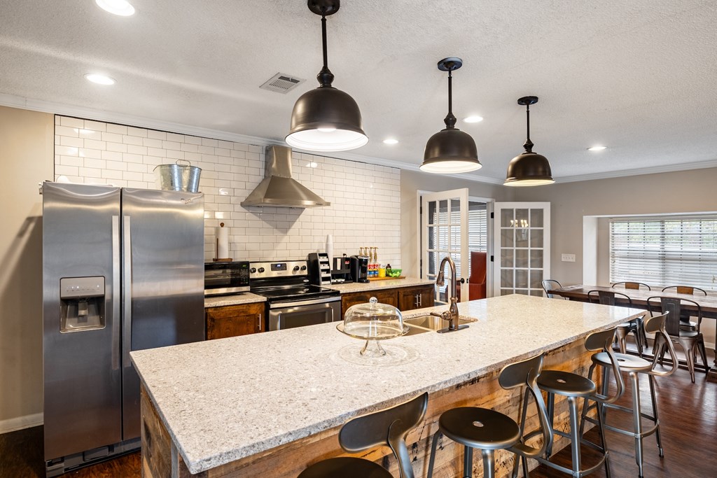 A kitchen with a marble countertop and stainless steel appliances.