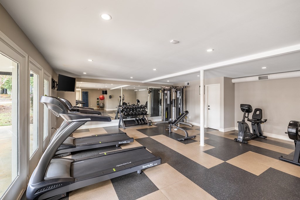 A spacious home gym with treadmills, weights, and exercise equipment.