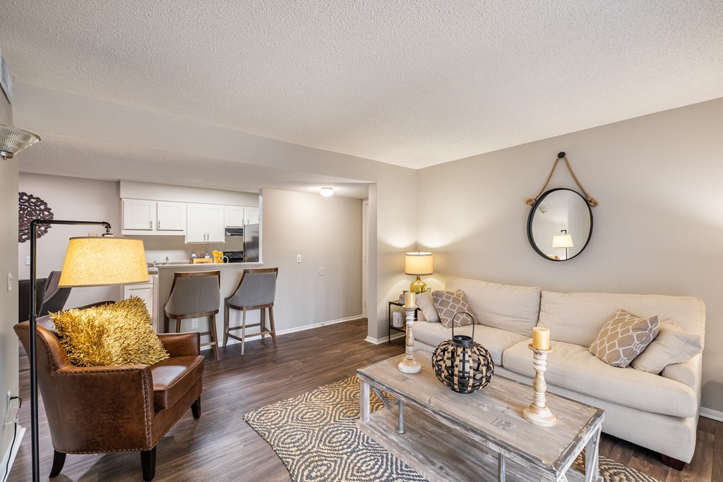 A living room with a white couch, a coffee table, and a lamp.