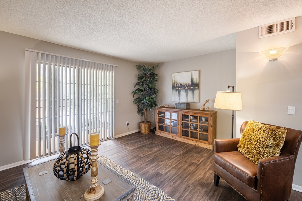 A living room with a brown leather couch and a wooden cabinet.