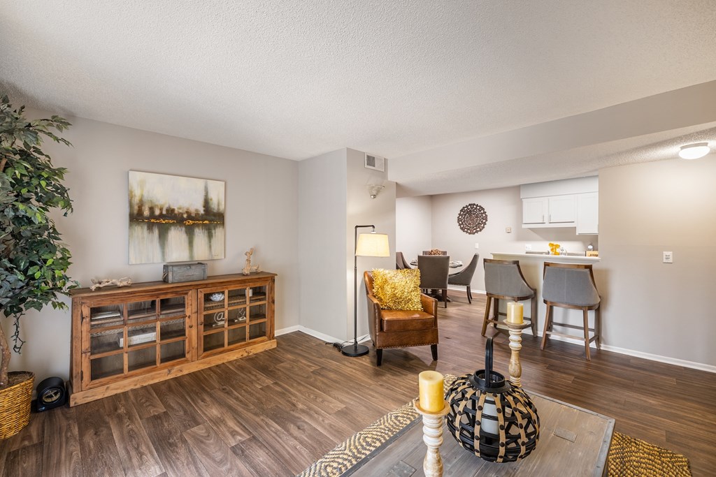 A living room with a wooden floor and a painting on the wall.