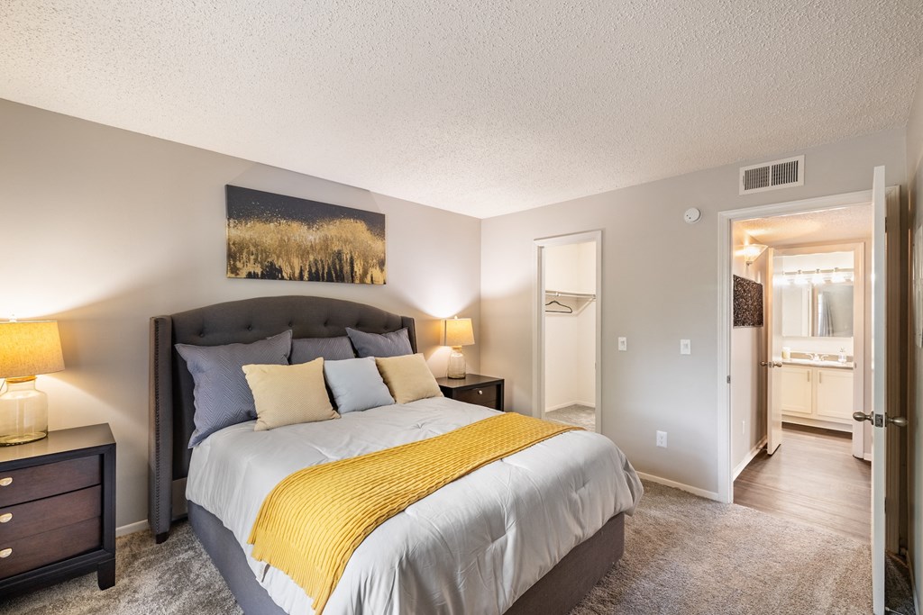 A bedroom with a large bed and a painting on the wall.