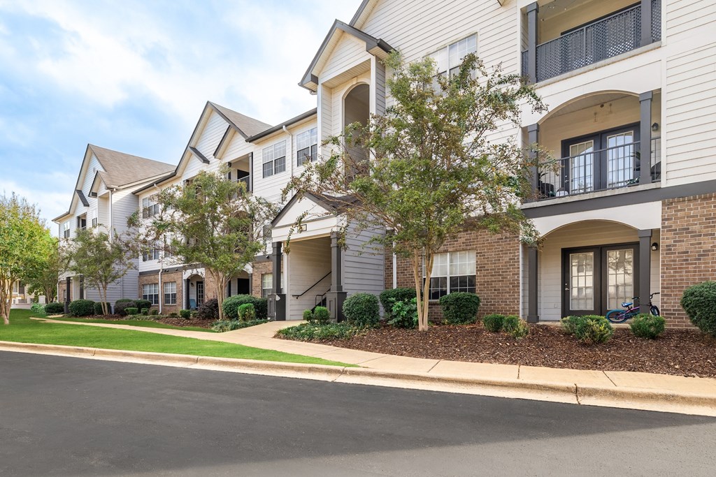 A row of townhouses with a tree in front of the first one.
