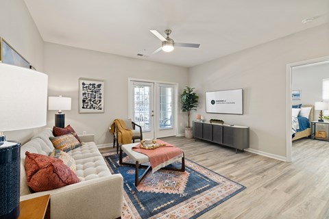 Interior Unit living room with a couch, a chair, a rug, and a ceiling fan.