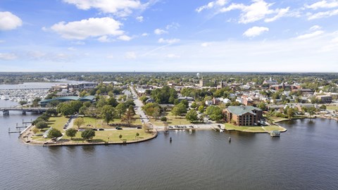 Outdoor Scenic View with Trees, Buildings and Water Nearby.
