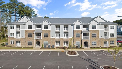 Apartment Complex Exterior with a Parking Lot in Front.