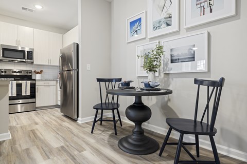 Eating Area with a Table and Two Chairs That are All Black.