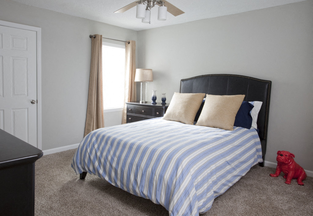 a bedroom with a bed and a blue and white striped comforter