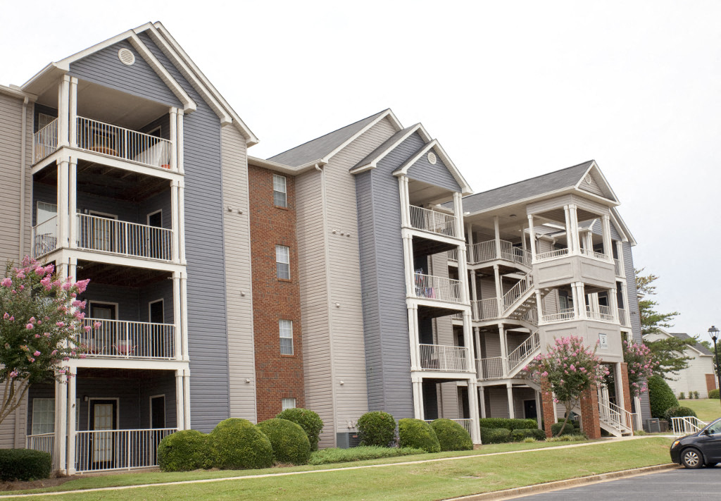 an apartment building with balconies and a car parked in front