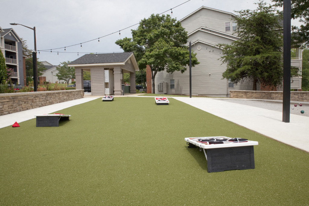 a backyard putting green with three bocce balls on it
