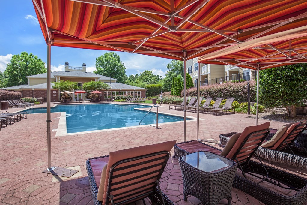 a swimming pool with chairs and umbrellas