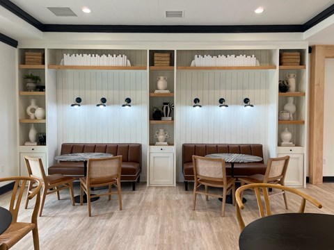 a dining room with tables and chairs and a wall with shelves