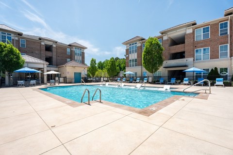 A large swimming pool in front of apartment buildings.
