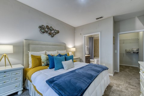 A bedroom with a white bed and yellow accents.
