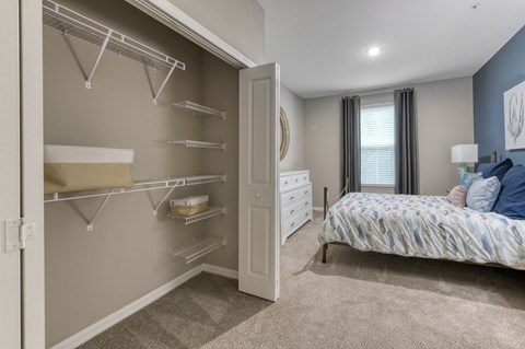 A bedroom with a large bed and a walk-in closet.