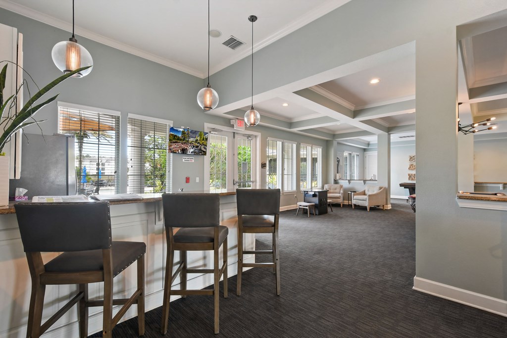 a clubhouse with a bar and chairs and a living room