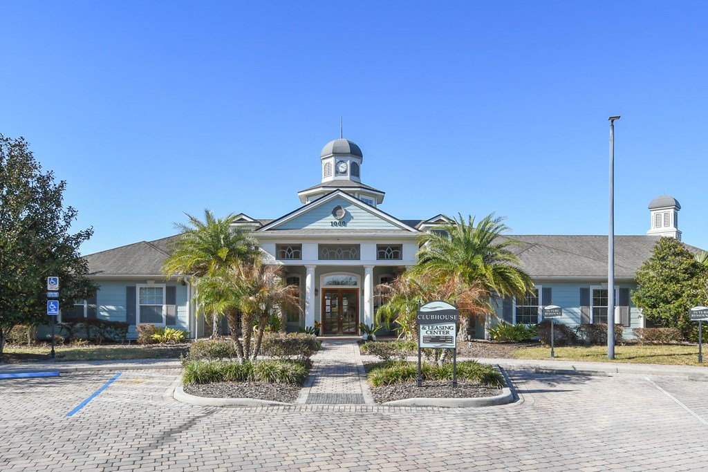 the front of a building with palm trees in front of it