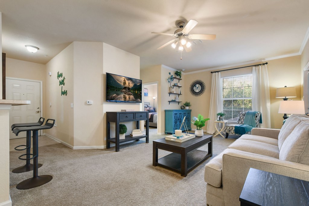 a living room with furniture and a ceiling fan