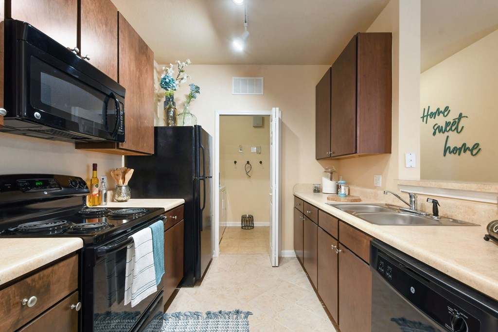 a kitchen with black appliances and wooden cabinets