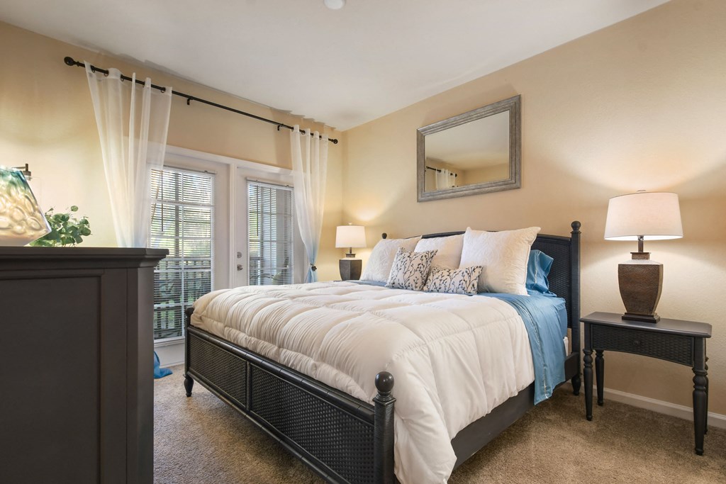 a bedroom with a bed and a door to a balcony