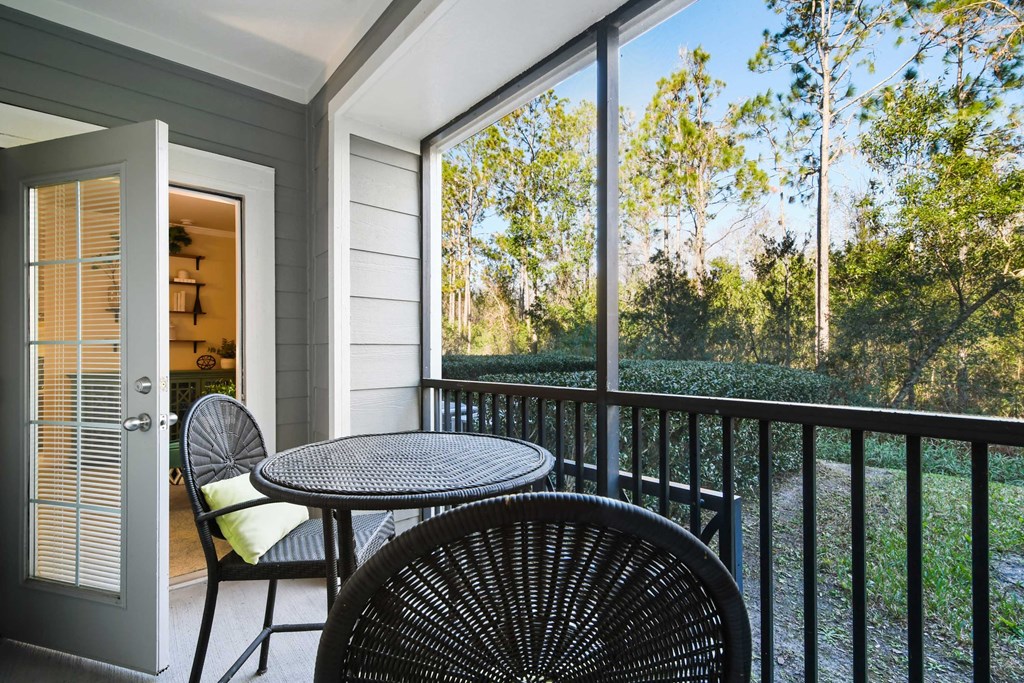 a patio with chairs and a table on a balcony