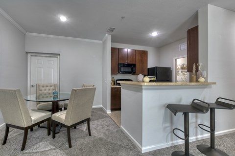 A kitchen with a table and chairs.