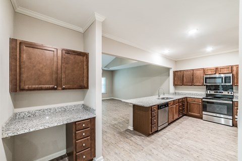 A kitchen with brown cabinets and a granite countertop.