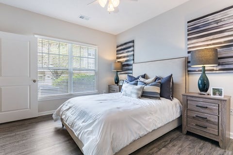 A bedroom with a large bed, a dresser, and a ceiling fan.