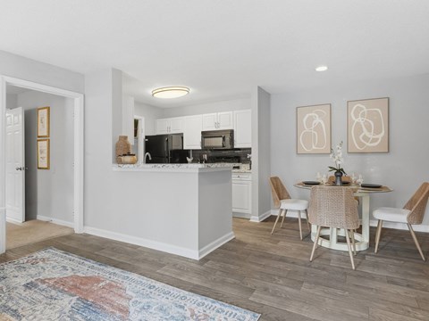 A kitchen with a dining table and chairs.