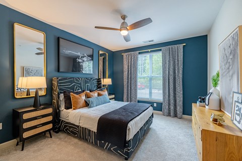 A bedroom with a bed, dresser, and mirror.