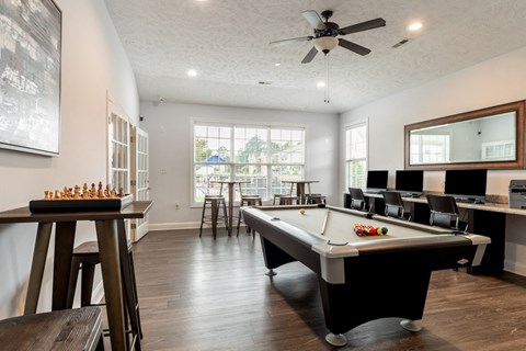 a game room with a pool table and a bar with chairs