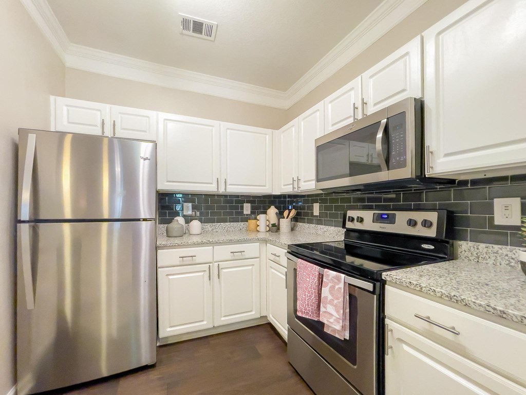 a kitchen with stainless steel appliances and white cabinets