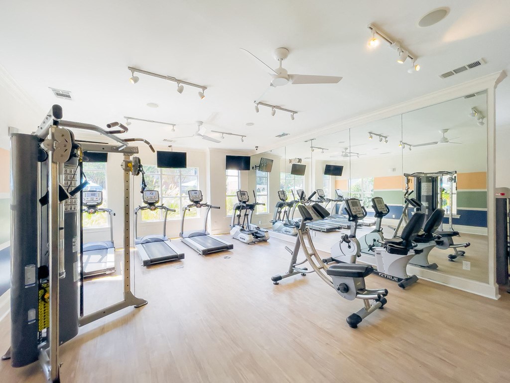 Amenities a gym with cardio machines and weights on a wooden floor
