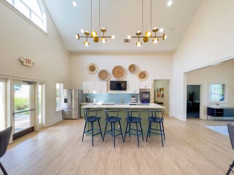 a kitchen with a bar and stools in the middle of a living room