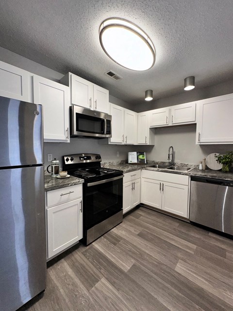 a kitchen with stainless steel appliances and white cabinets