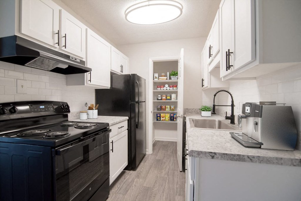 a kitchen with black appliances and white cabinets