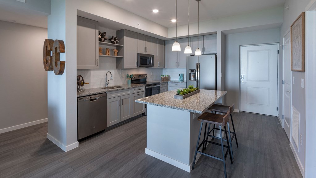 a kitchen with white cabinets and a granite counter top