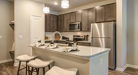 A kitchen with a white counter top and stainless steel appliances.